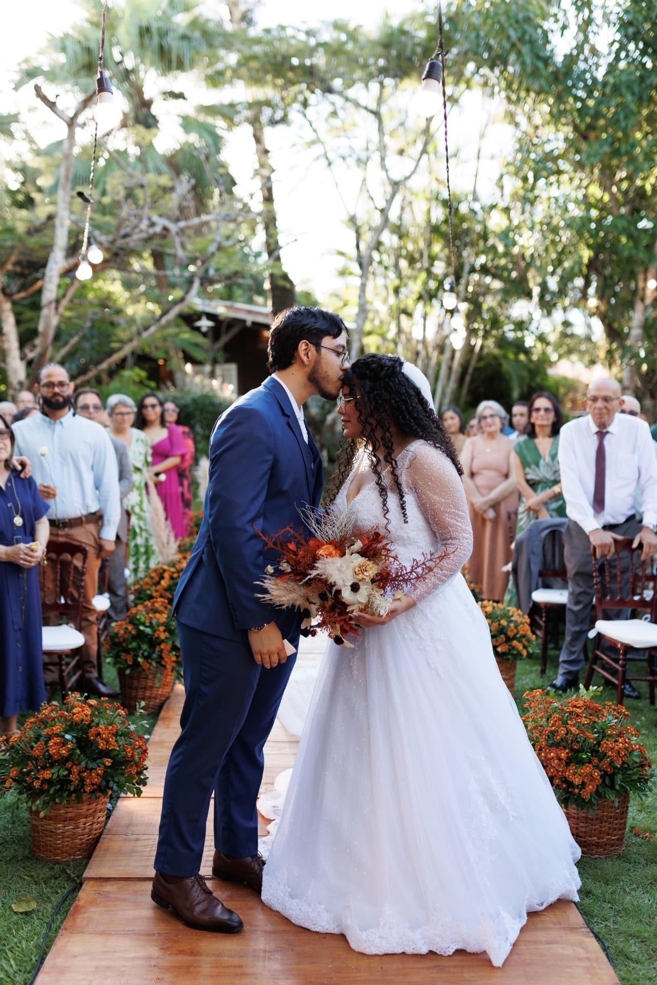 Noivos se beijando no corredor de flores ao fim da cerimônia
