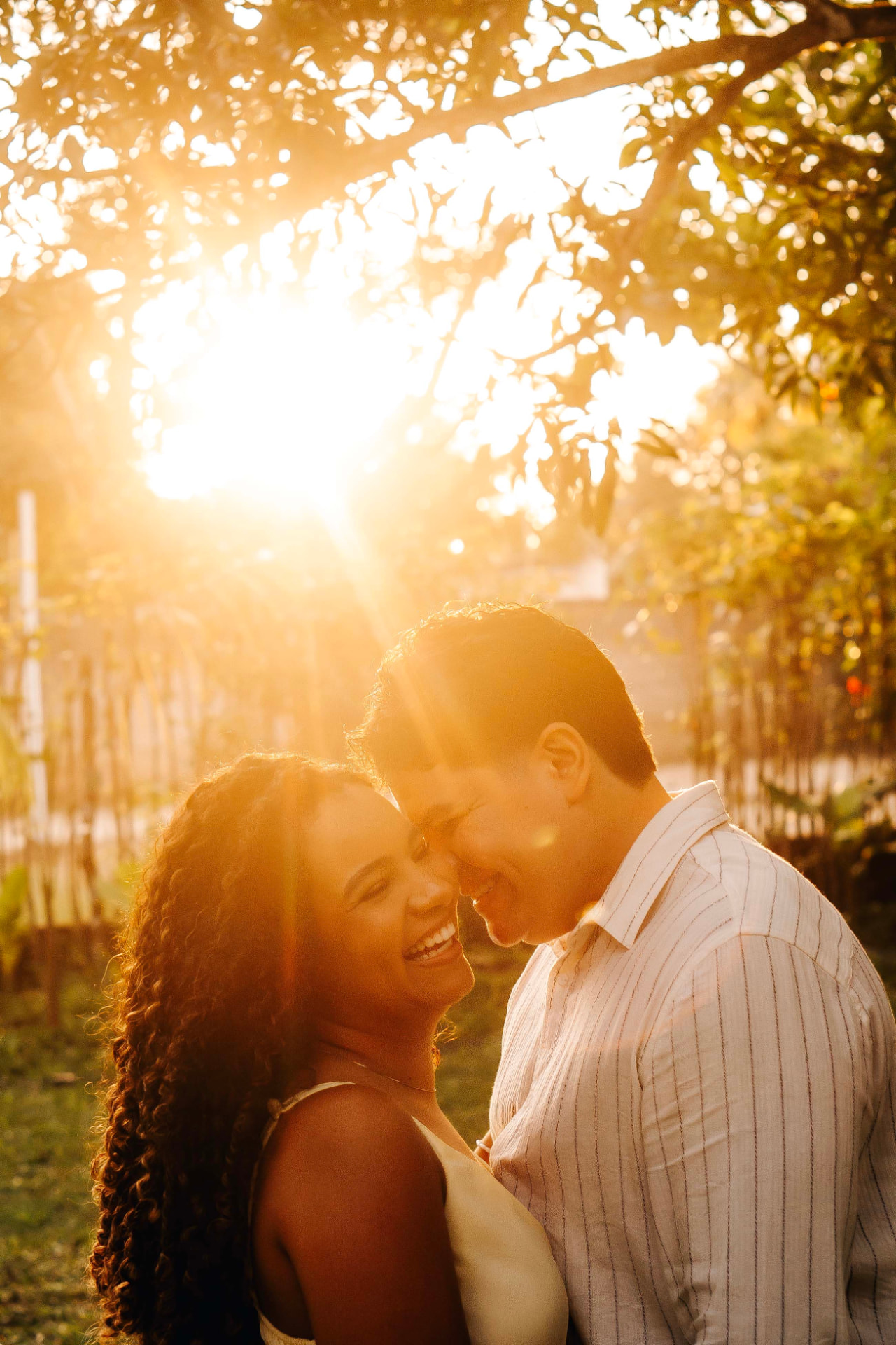 Casal em ensaio ao pôr do sol na área verde da chácara